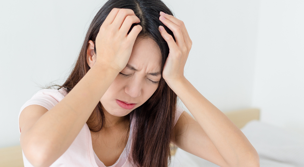 頭を抱え込み、強いストレスや【自律神経】の乱れによる深刻な不調に悩まされている状況です。どうにもならない慢性的な頭痛やイライラ感で、心身ともに余裕がなくひどく辛そうな感情を表現しています。